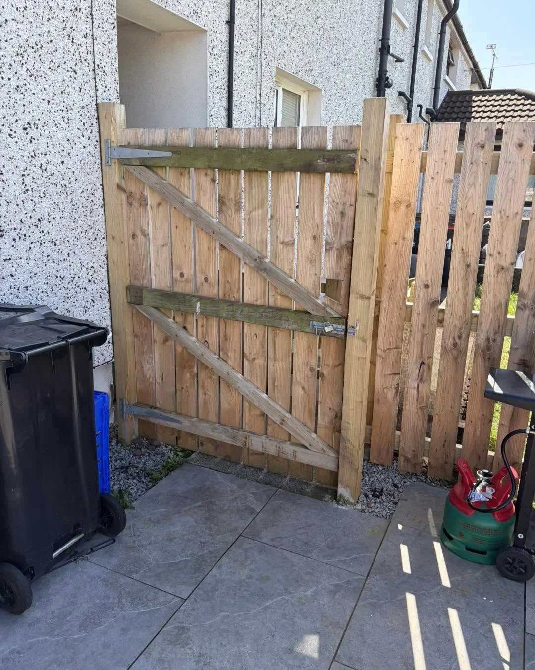 Timber garden gate with diagonal bracing and matching fencing