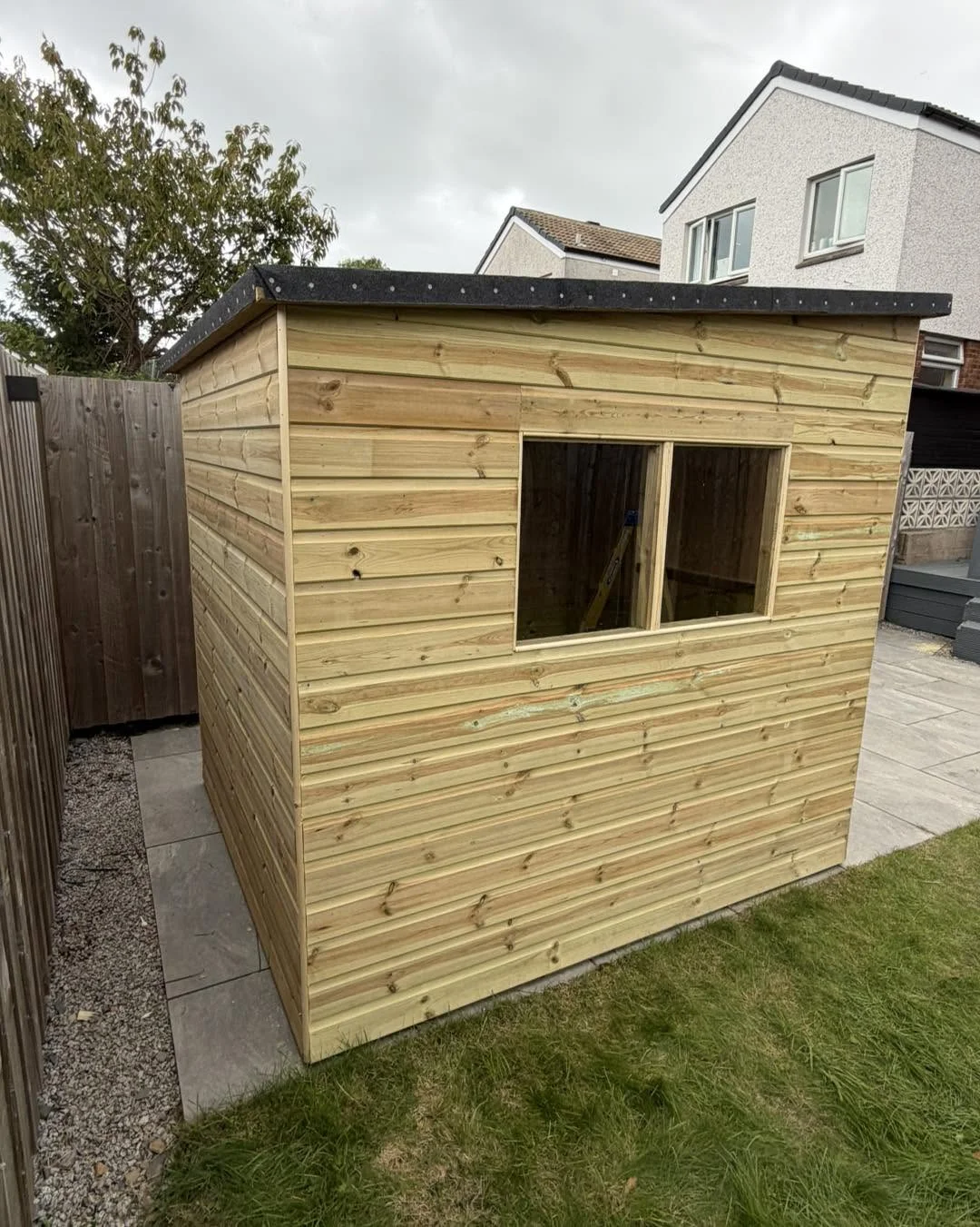 Timber garden shed with a side window and a flat roof